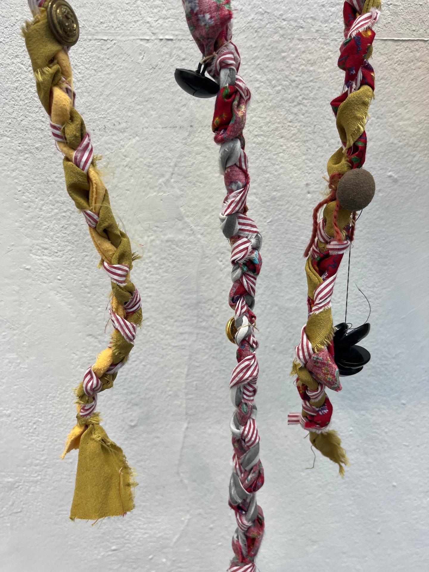 Close-up of braided fabric cords with buttons woven in